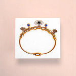 Bracelet on geometric prop with peach color gradient in the background.