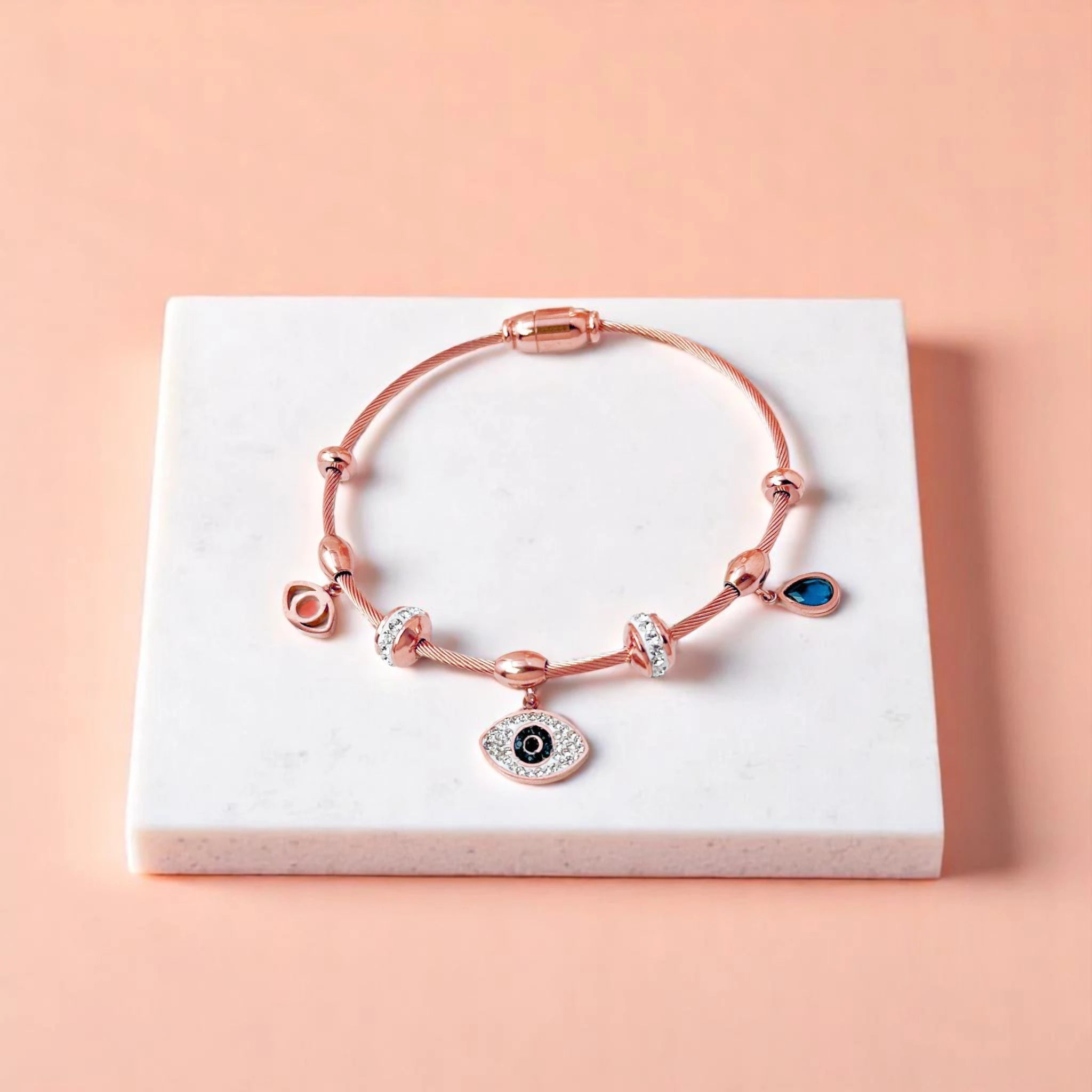 Bracelet on geometric prop with peach color gradient in the background.