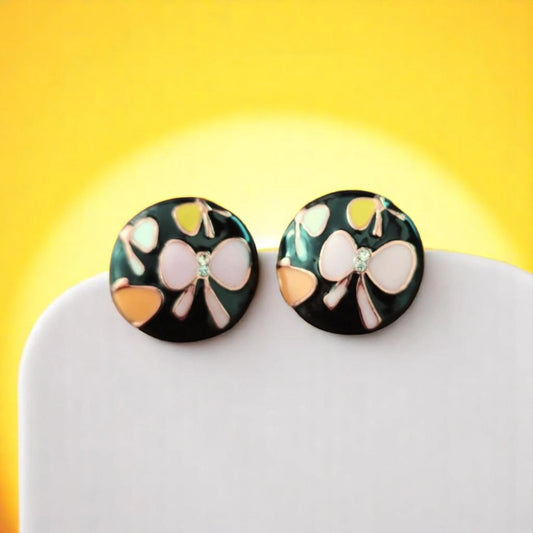 Colorful circular earrings featuring bows and jewels against a bright yellow background. Perfect for a stylish accessory.