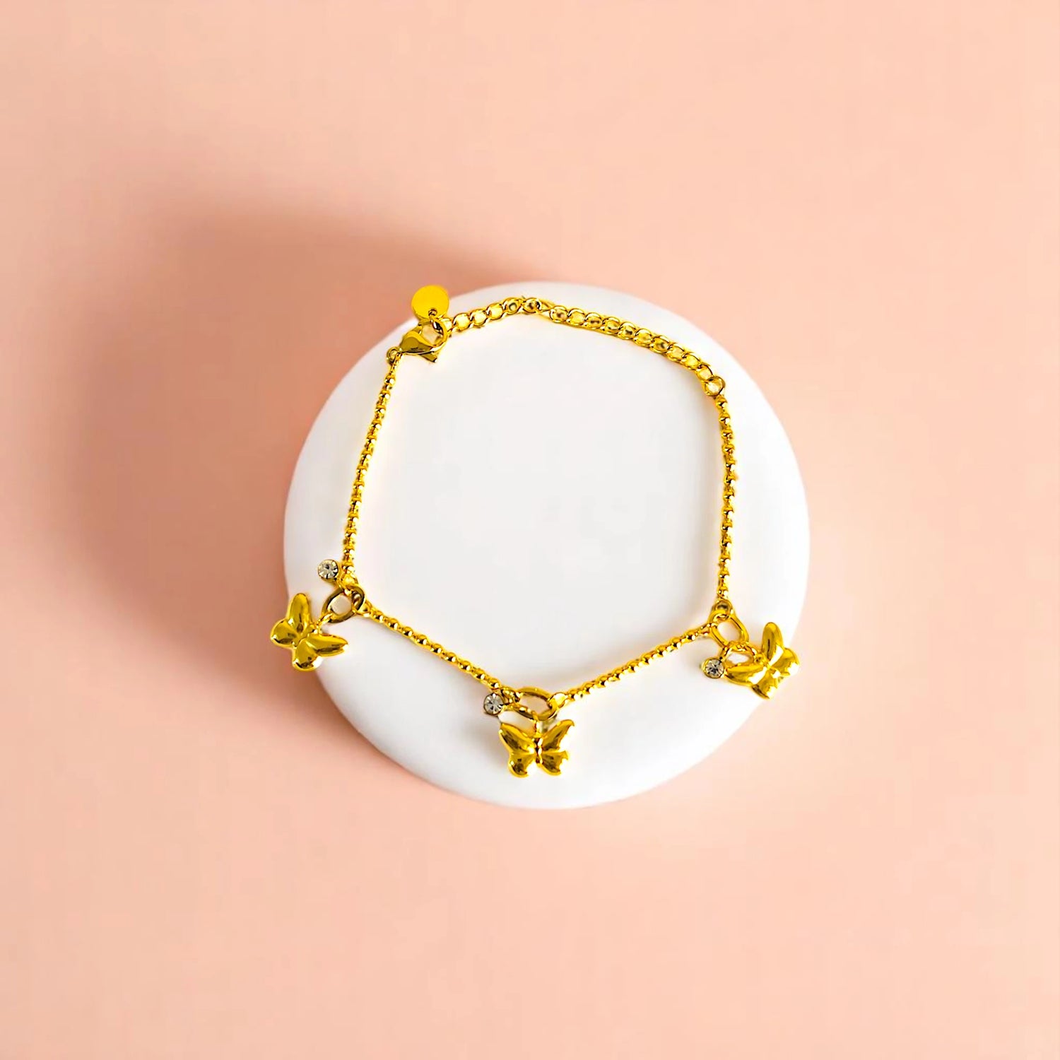 Bracelet on geometric prop with peach color gradient in the background.