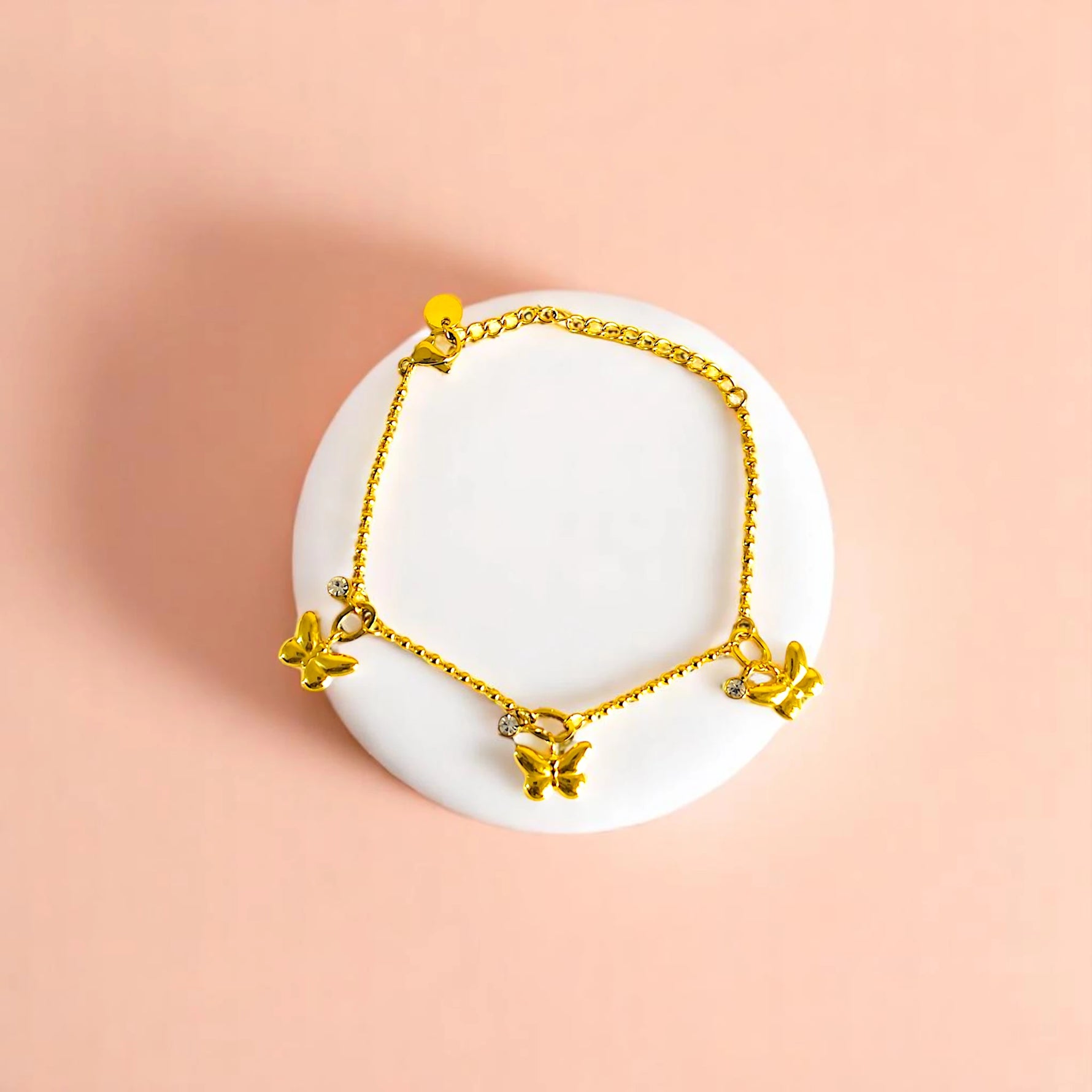Bracelet on geometric prop with peach color gradient in the background.