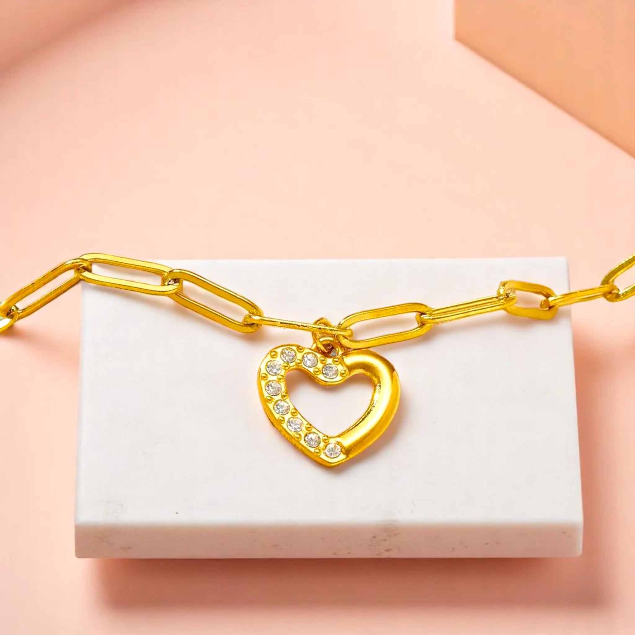 Bracelet on geometric prop with peach color gradient in the background.