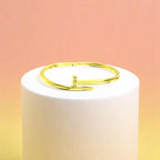 Bracelet on geometric prop with peach color gradient in the background.