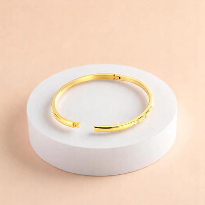 Bracelet on geometric prop with peach color gradient in the background.