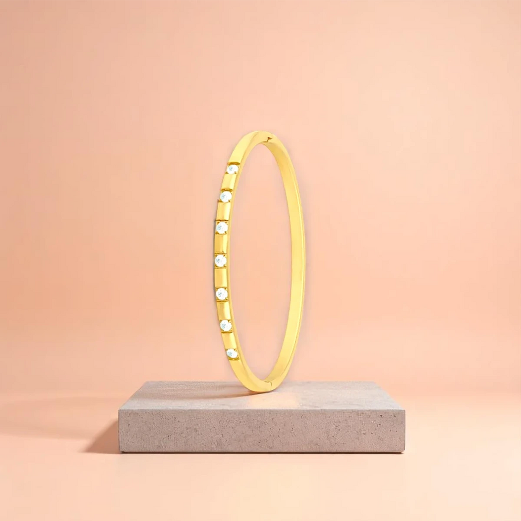 Bracelet displayed on a travertine stone slab with a peach-colored gradient in the background.