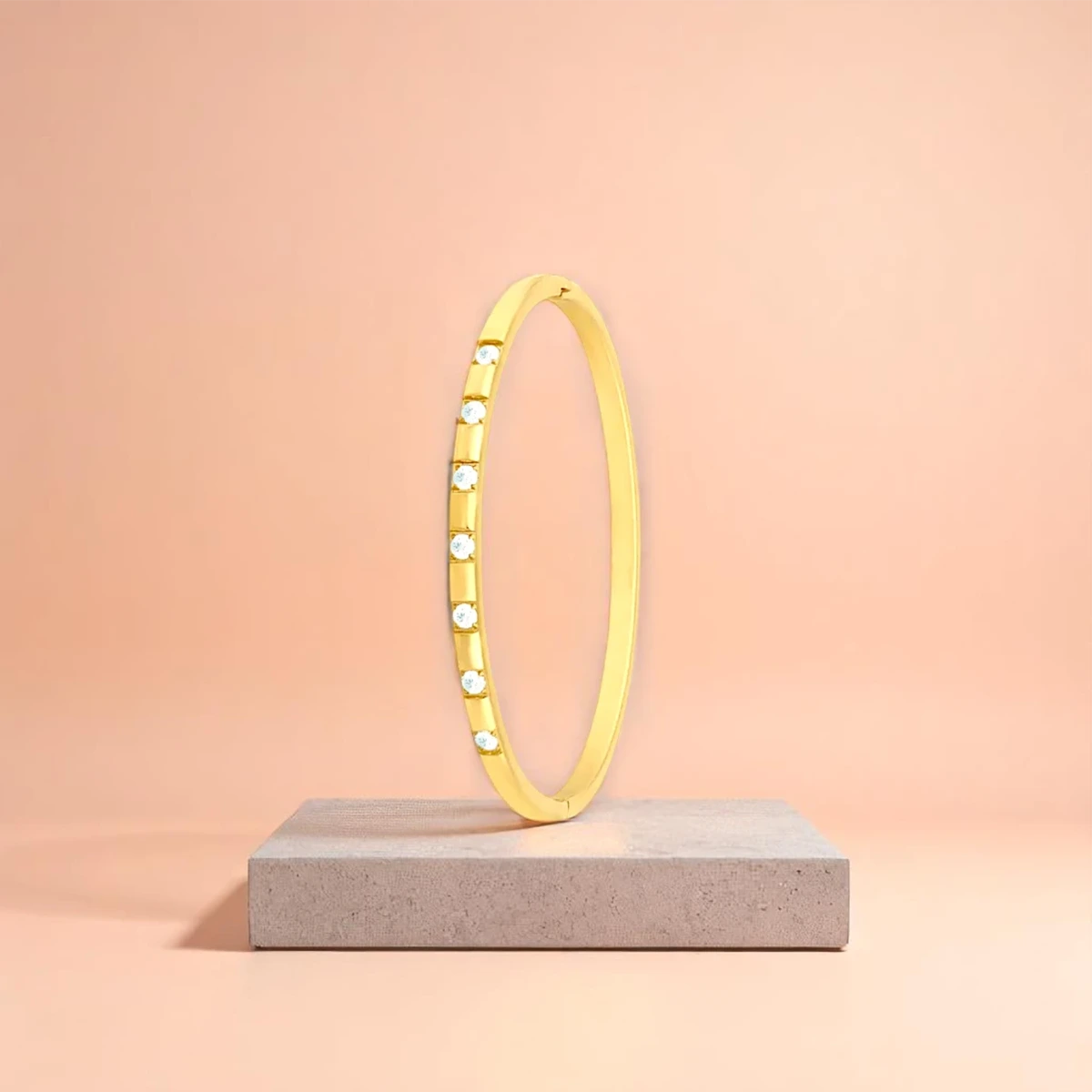 Bracelet displayed on a travertine stone slab with a peach-colored gradient in the background.
