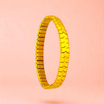 Bracelet on a color gradient of peach tones background.