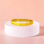 Bracelet on geometric prop with peach color gradient in the background.