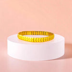 Bracelet on geometric prop with peach color gradient in the background.