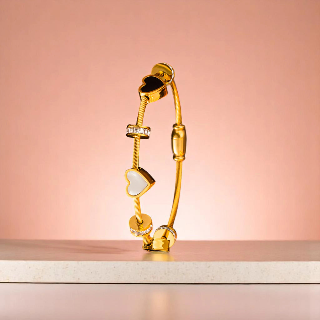 Bracelet on platform with peach-colored gradient in the background.