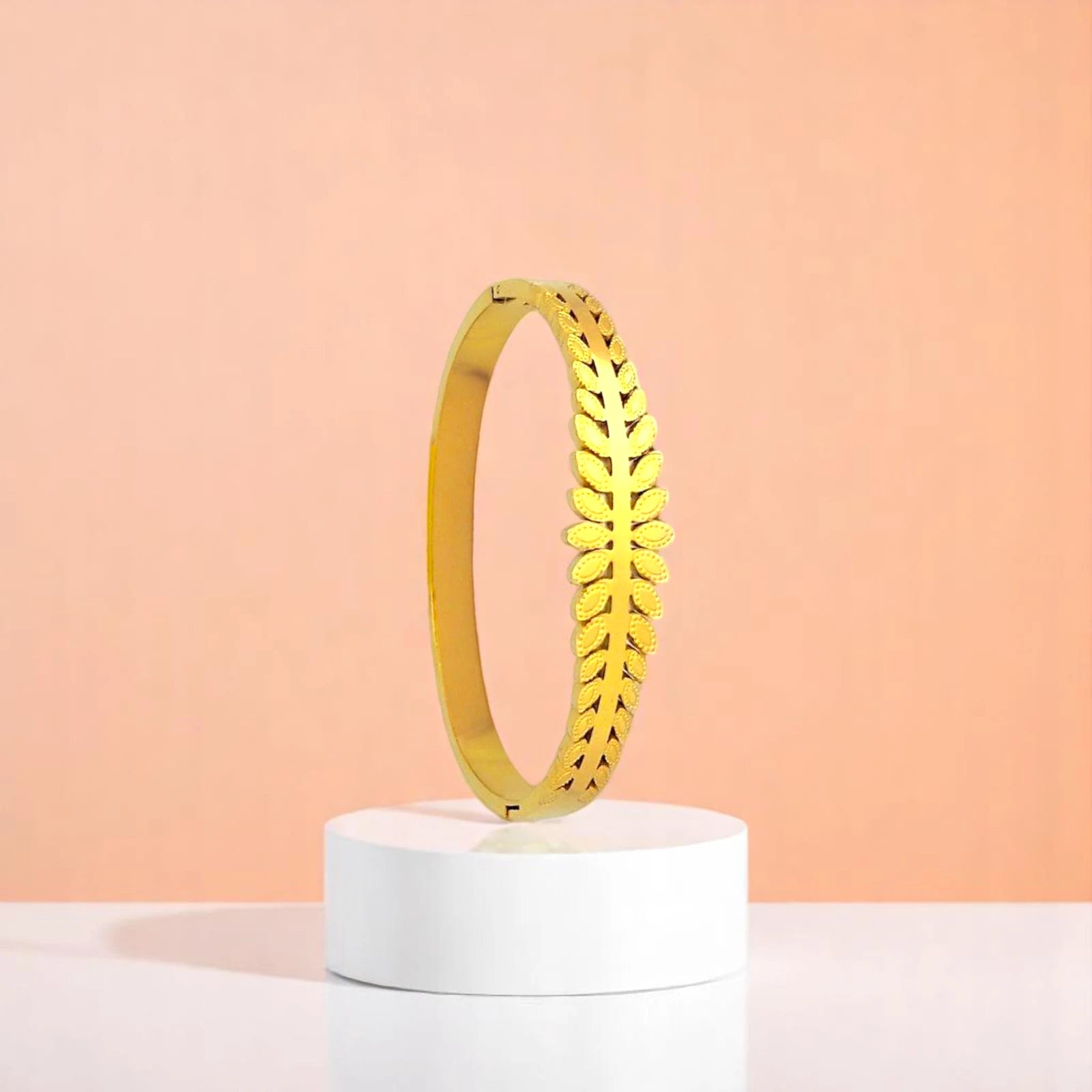 Bracelet on geometric prop with peach color gradient in the background.