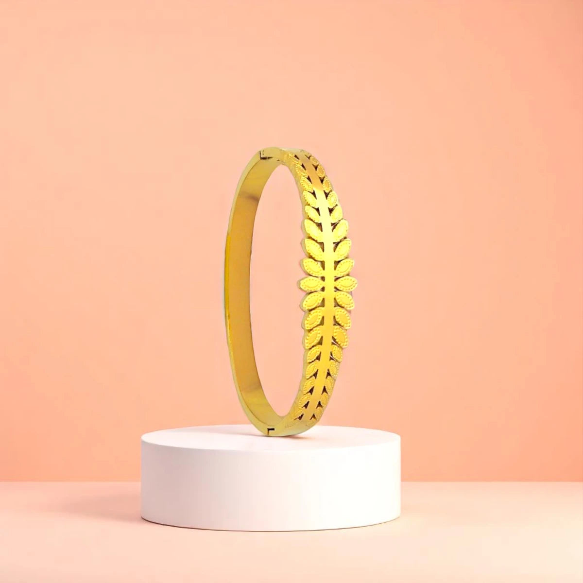 Bracelet displayed on a white pedestal against a soft peach background.