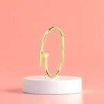 Bracelet displayed on a white pedestal against a soft peach background.