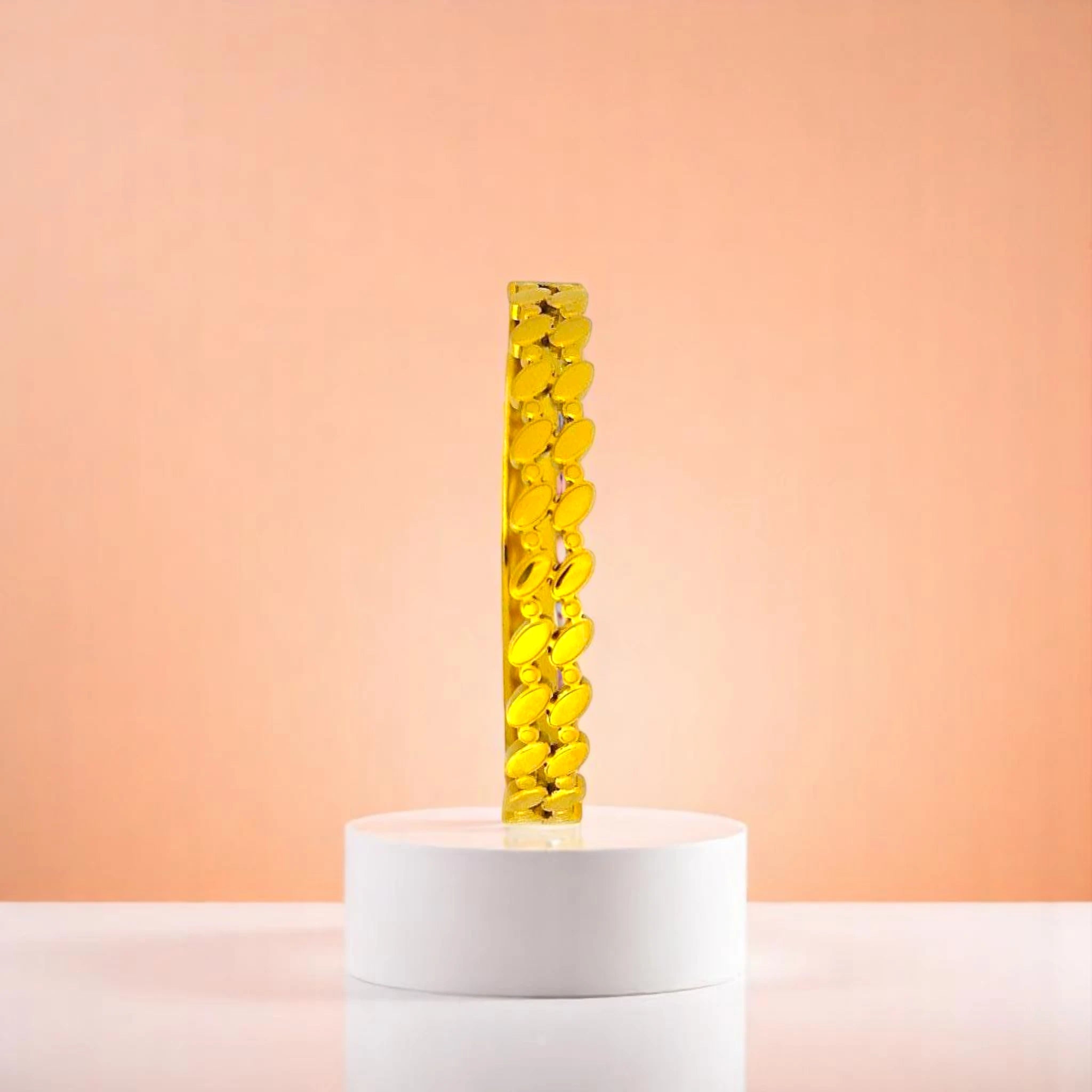 Bracelet on geometric prop with peach color gradient in the background.