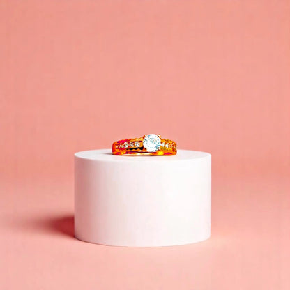 Ring on a white cylindrical geometric prop with a peach color gradient in the background.
