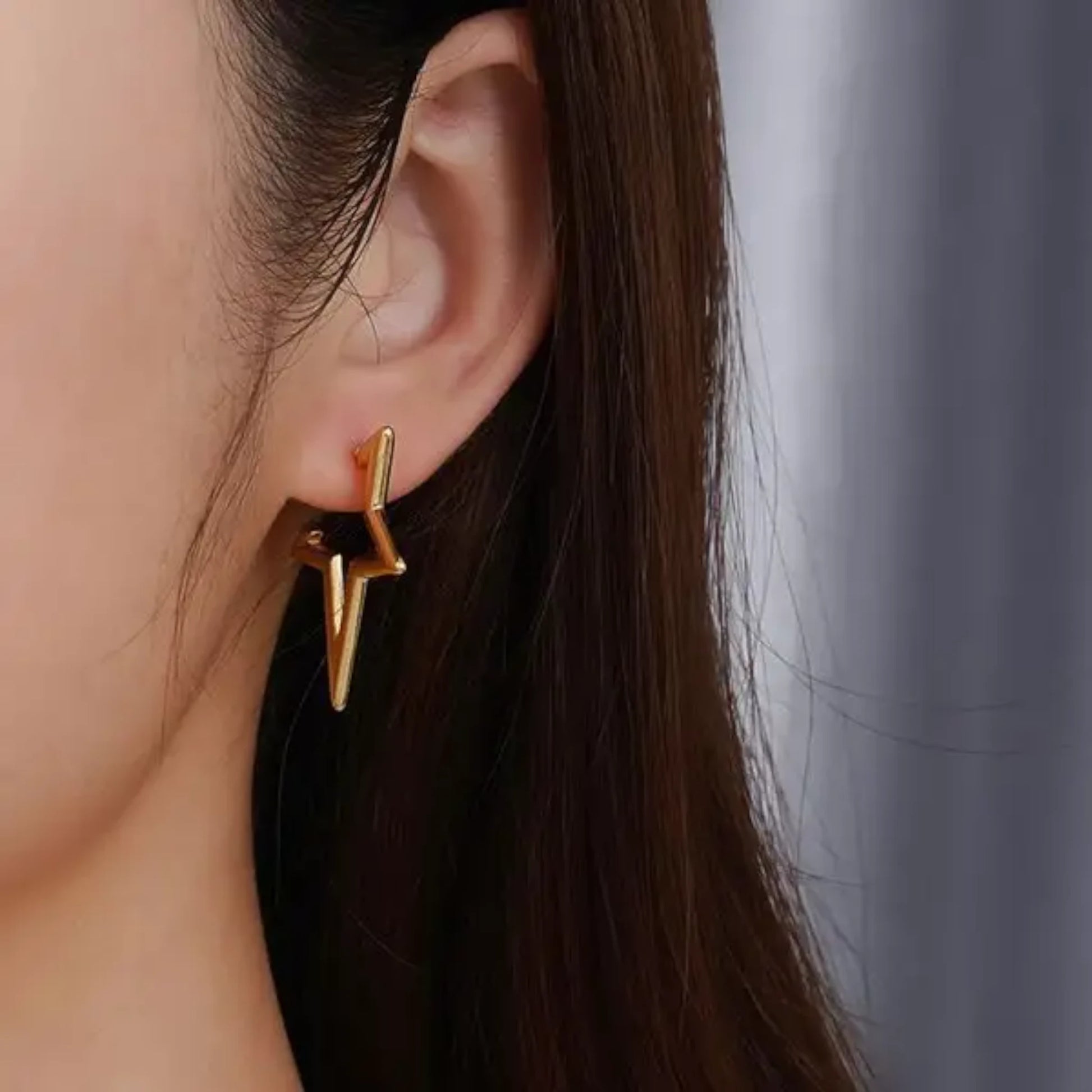 Gold Star Hoop Earrings worn by a model.