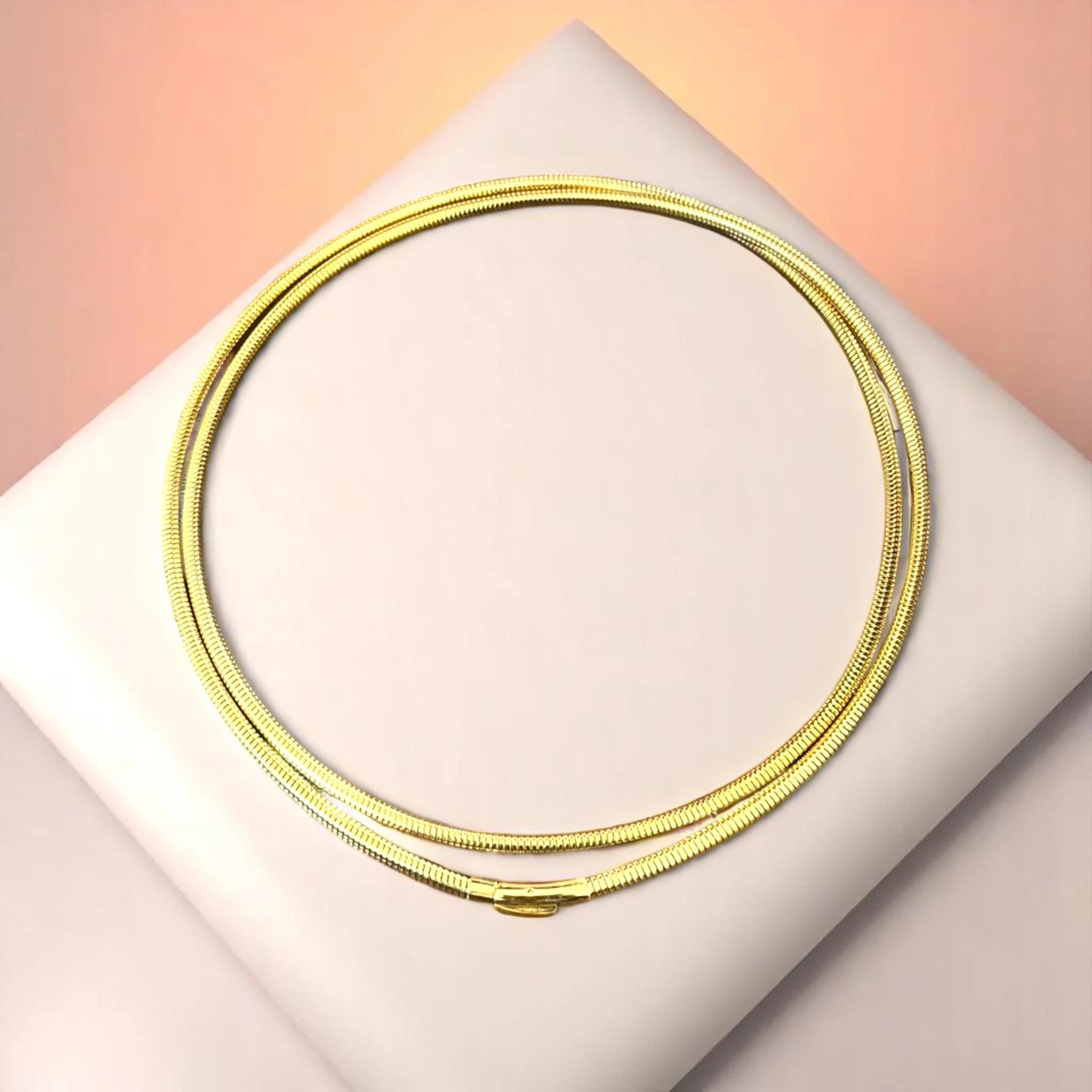 Bracelet on geometric prop with peach color gradient in the background.