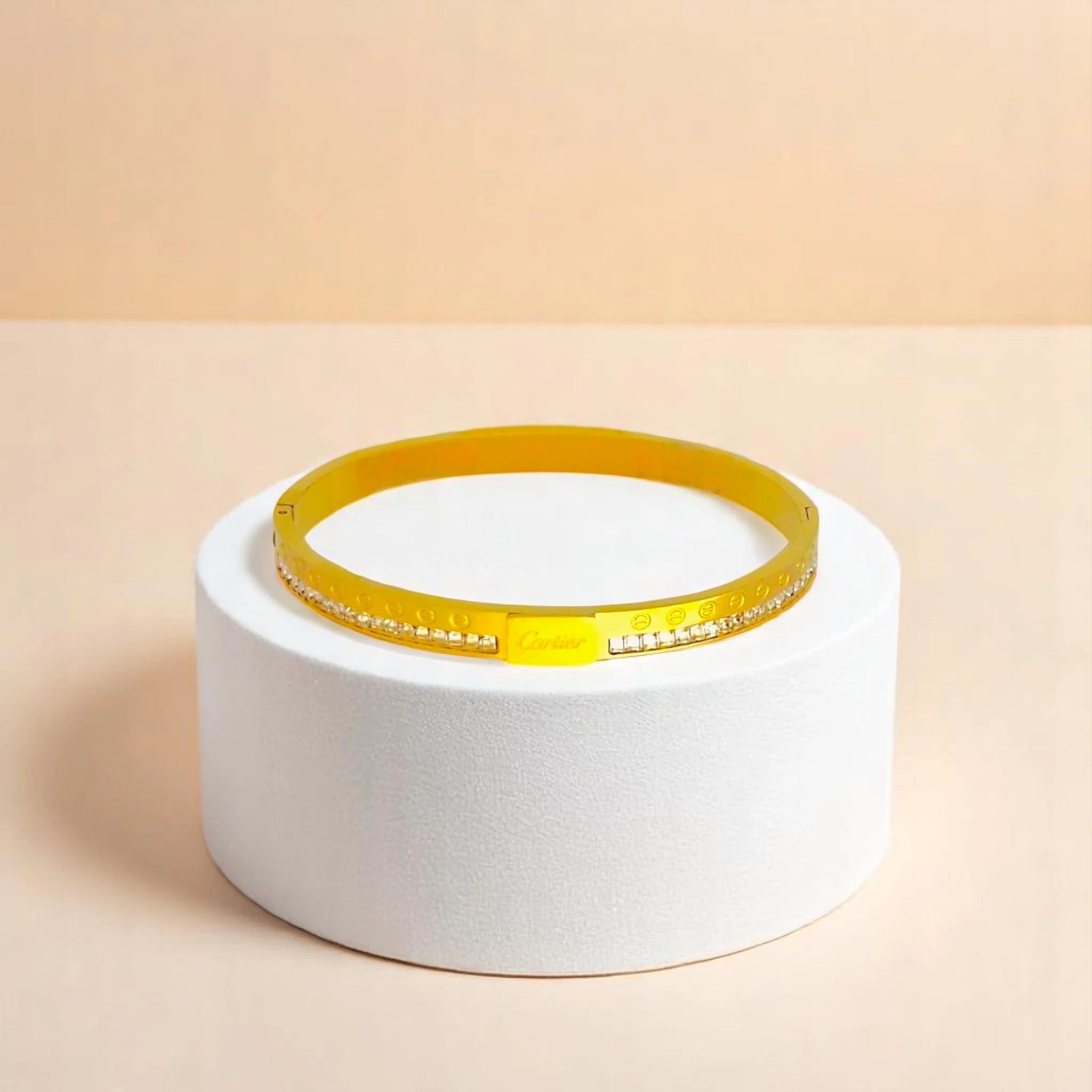 Bracelet on geometric prop with peach color gradient in the background.