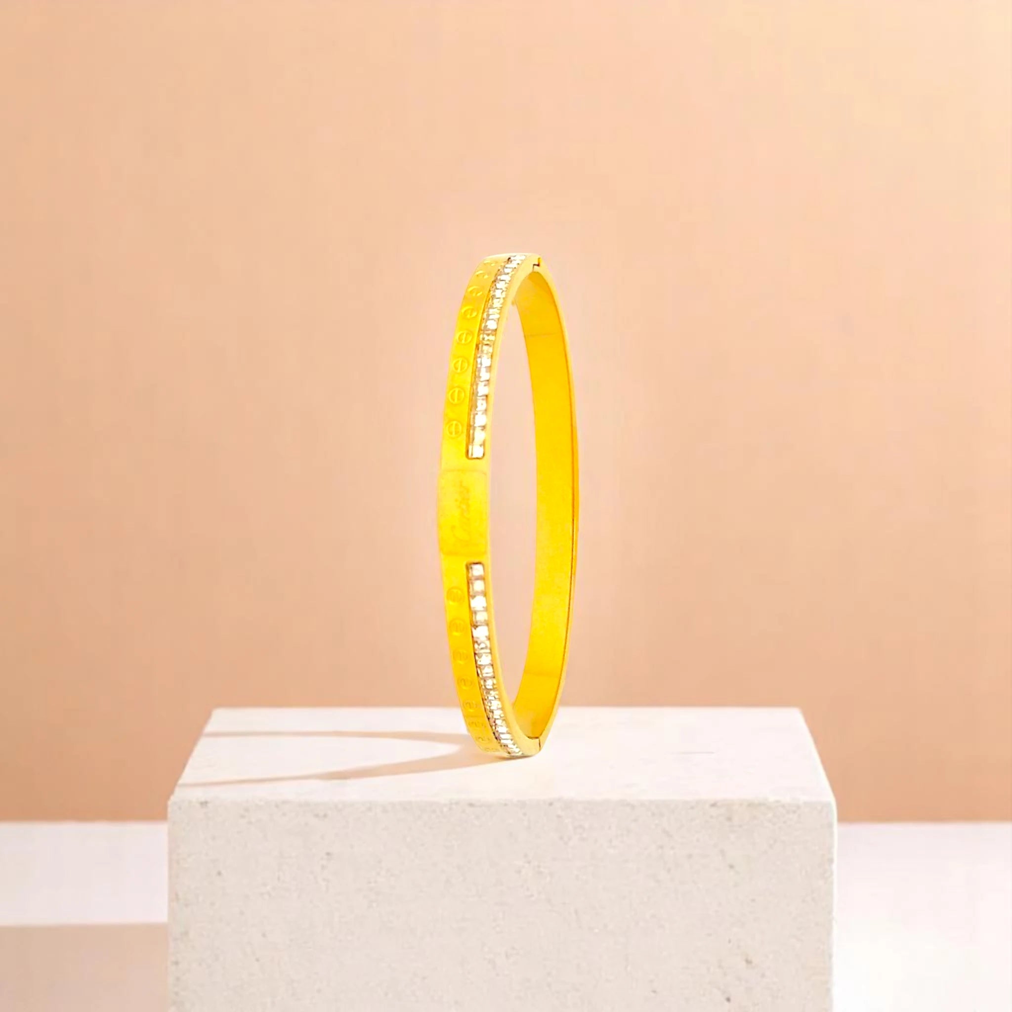 Bracelet on geometric prop with peach color gradient in the background.