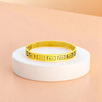 Bracelet on geometric prop with peach color gradient in the background.