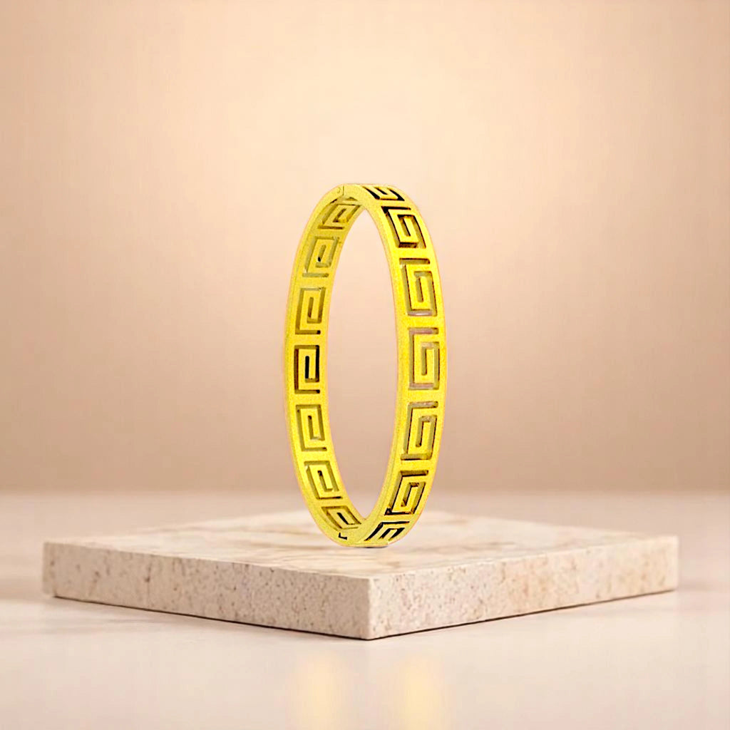 Bracelet on geometric prop with peach color gradient in the background.