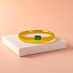 Bracelet displayed on a light-colored travertine stone slab with a peach-colored gradient in the background.