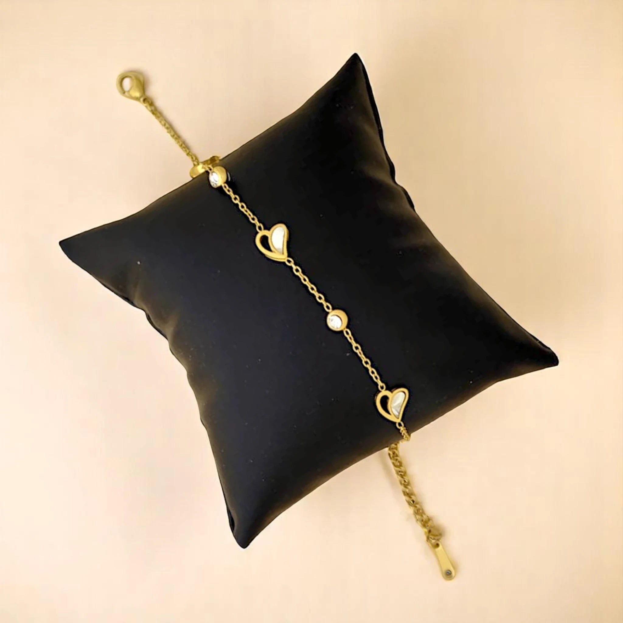 Bracelet rests elegantly on a black pillow against a neutral background.