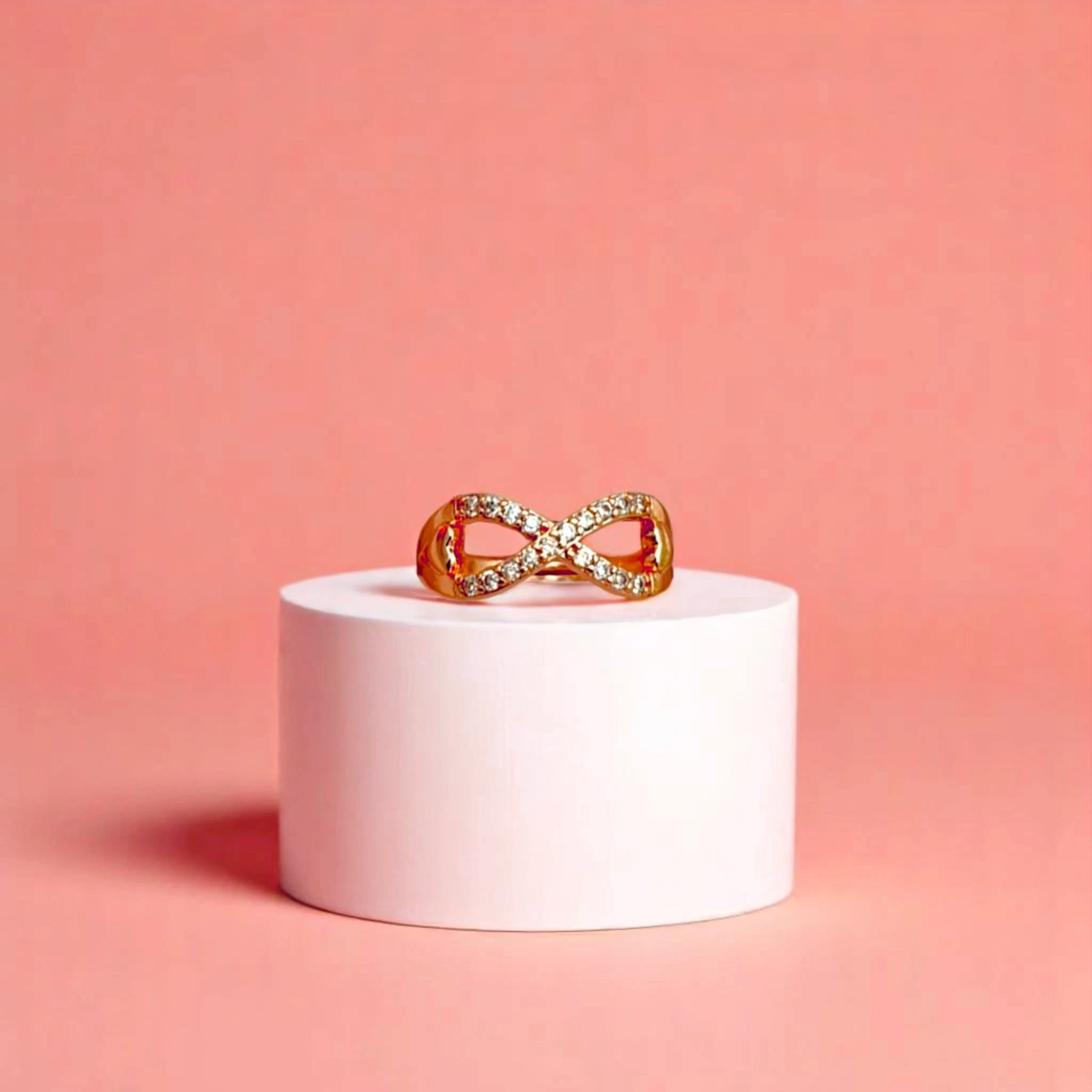 Ring on a white cylinder geometric prop with a peach color gradient in the background.