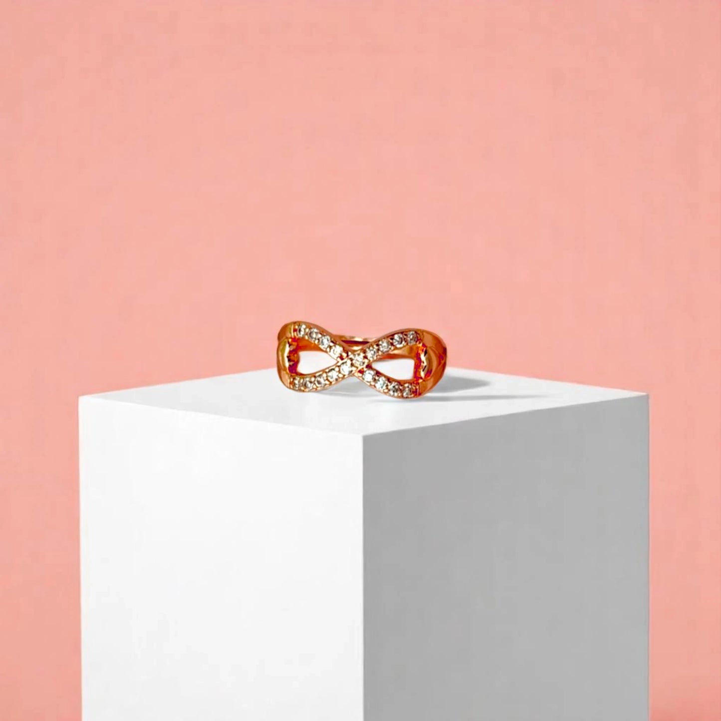 Ring on a white cube geometric prop with a peach color gradient in the background.