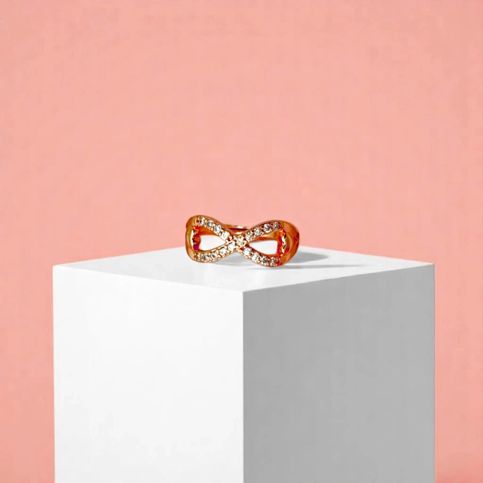 Ring on a white cube geometric prop with a peach color gradient in the background.