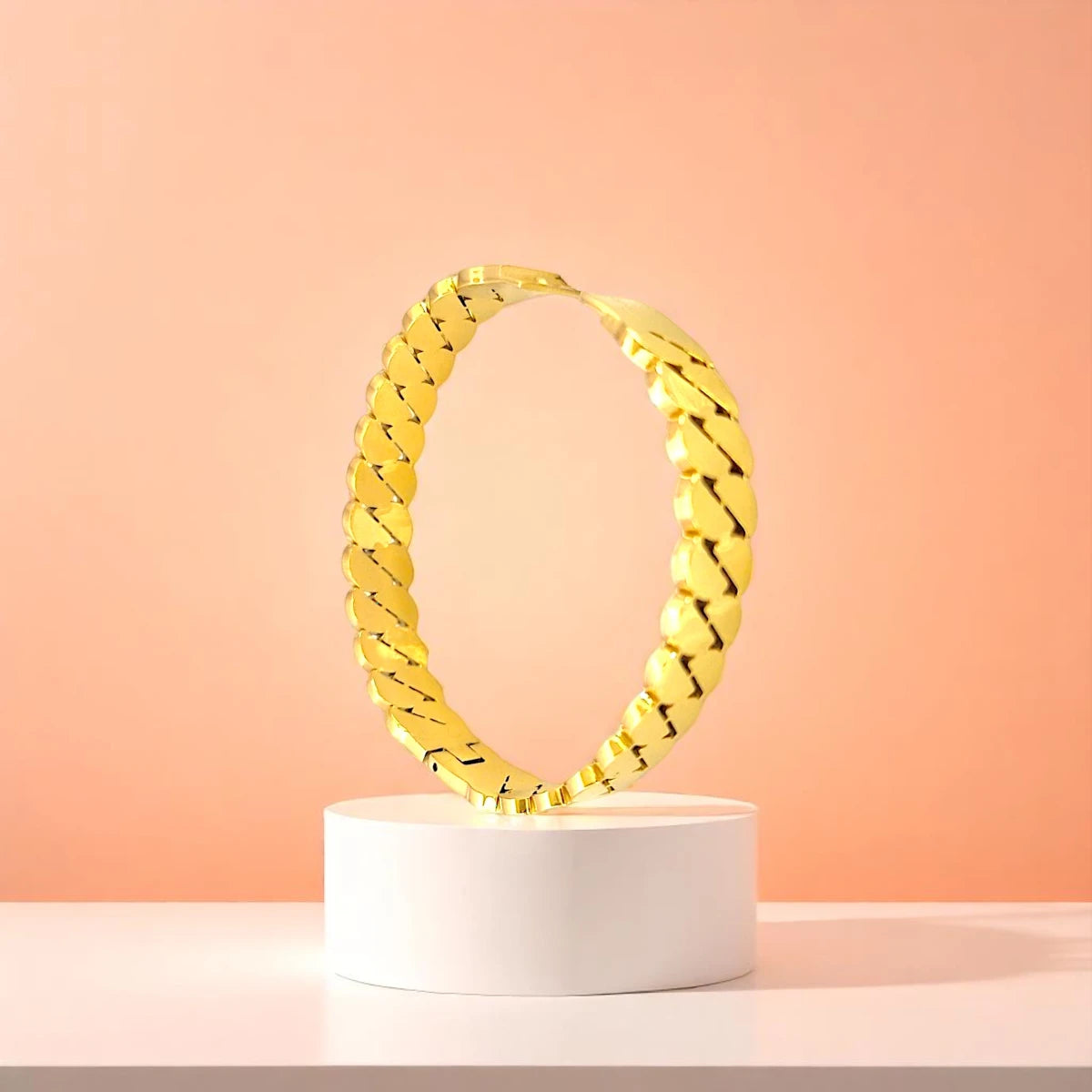 Bracelet displayed on a white pedestal against a soft peach background.
