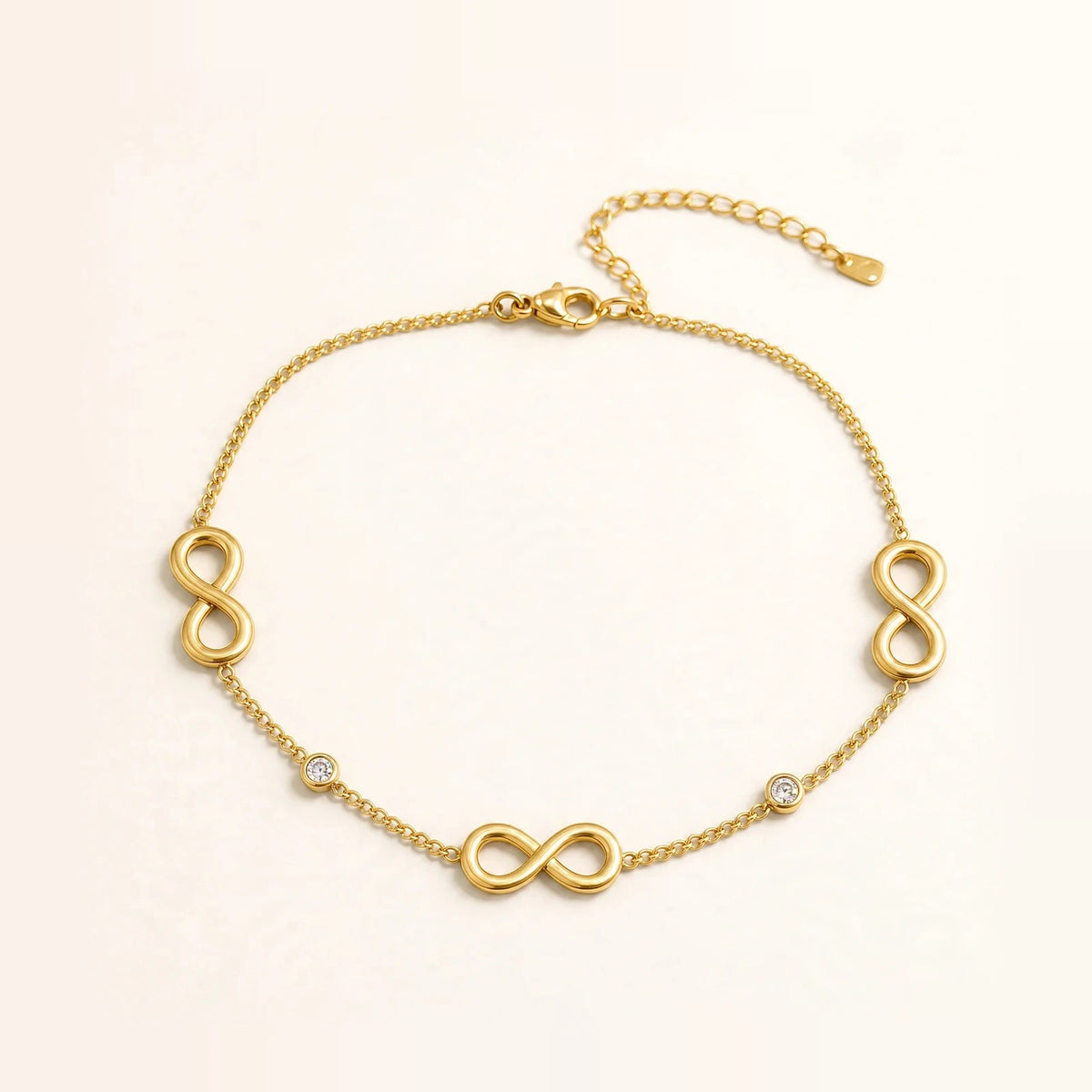 Gold infinity anklet with 3 infinity symbols and 2 bezel CZ stones, cable chain, lobster clasp.