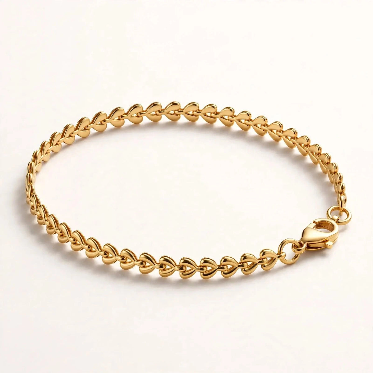 Gold teardrop chain bracelet side angle on acrylic riser, depth and clasp.