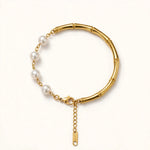 Side angle view of gold bamboo pearl bracelet with pearl-side extension and gold S.STEEL tag reaching lobster clasp