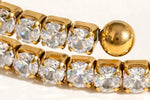 Extreme macro of gold tennis links, CZ stones and ball end, mirror polish.