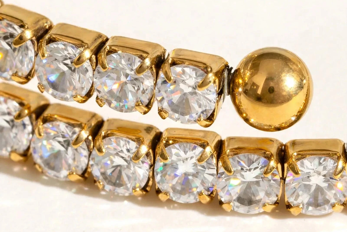 Extreme macro of gold tennis links, CZ stones and ball end, mirror polish.