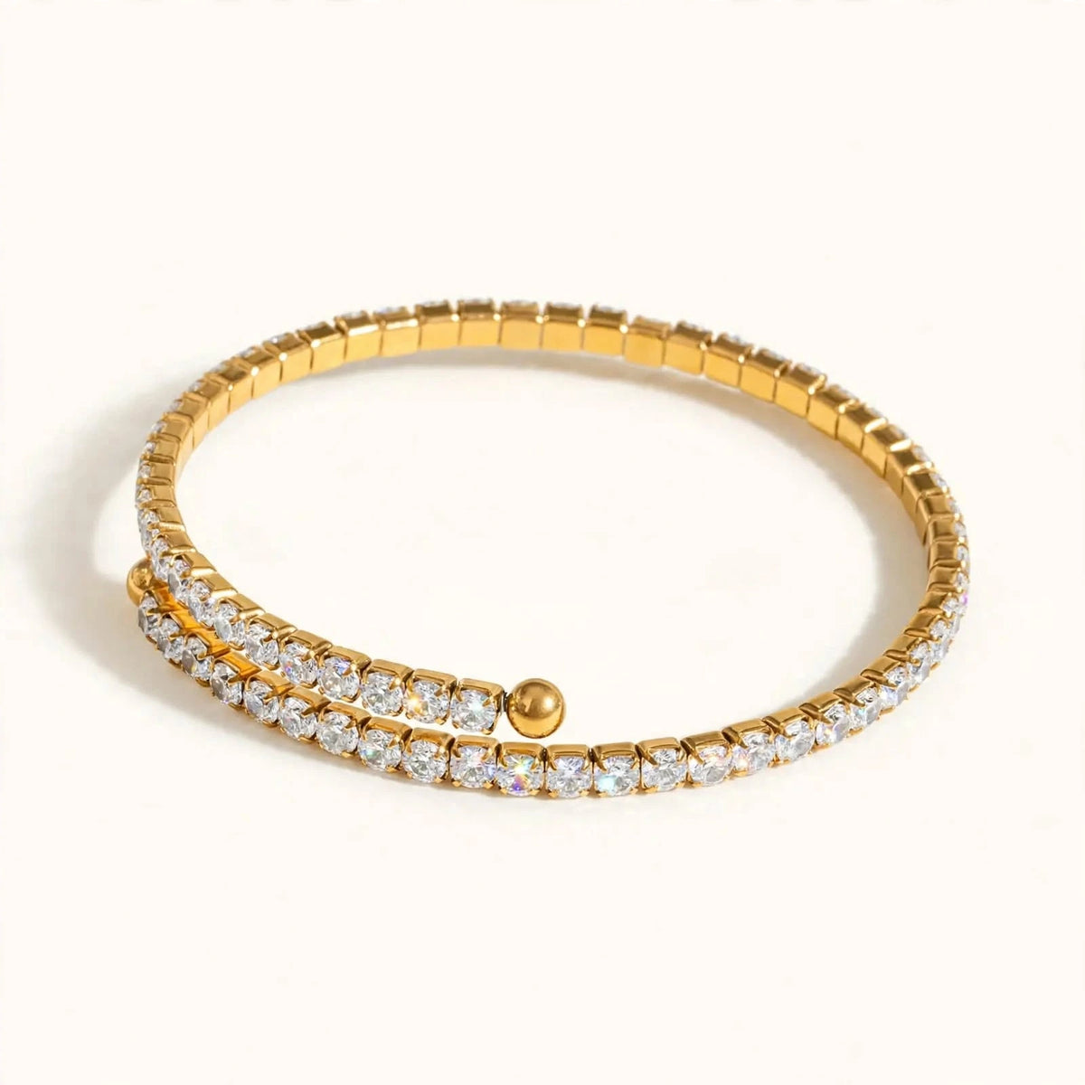 Hand on hip with gold spiral tennis bracelet, sage satin blouse, nude manicure.