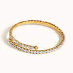 Hand on hip with gold spiral tennis bracelet, sage satin blouse, nude manicure.