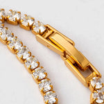 Macro of gold tennis bracelet clasp and cubic zirconia settings showing craftsmanship detail