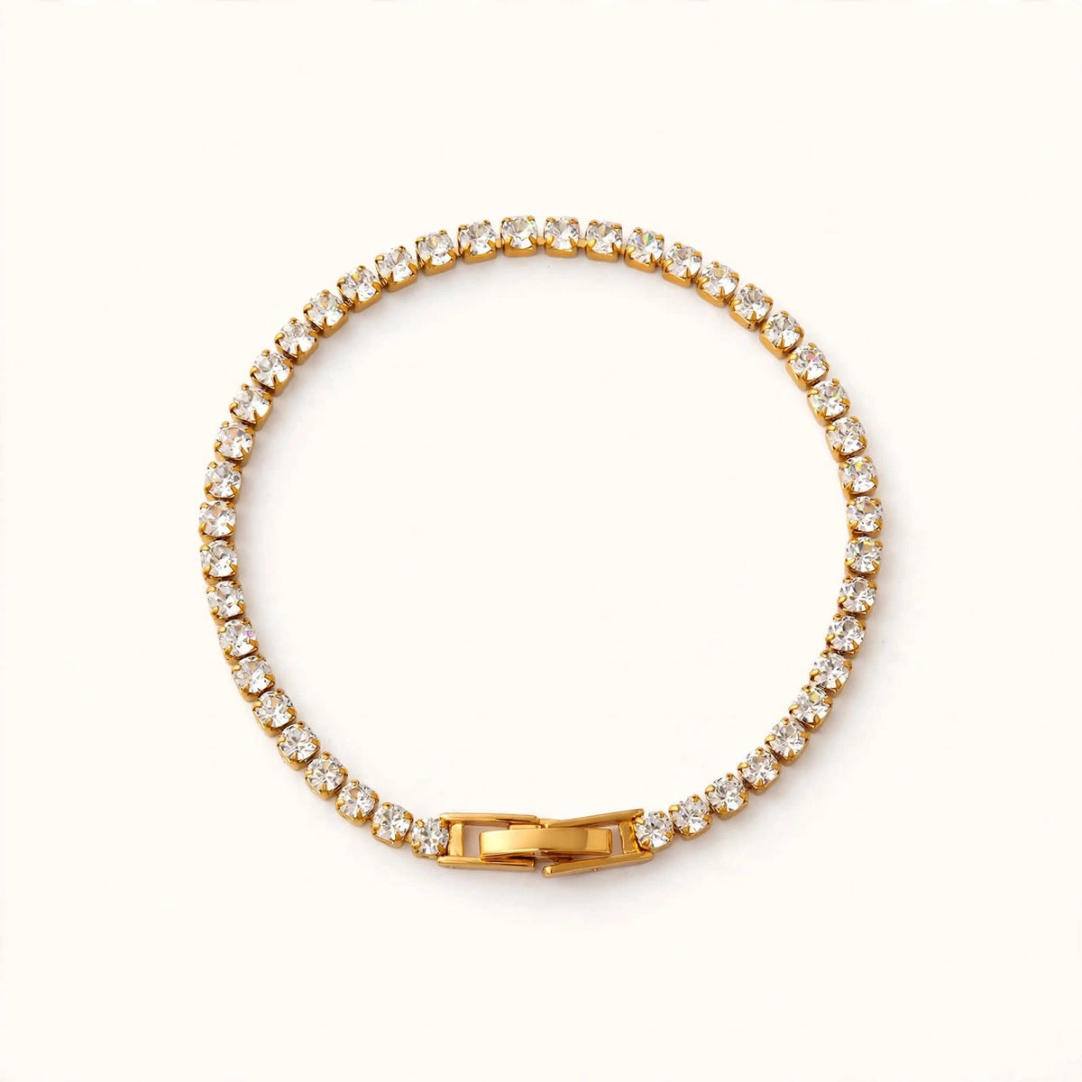 Gold tennis bracelet with round cubic zirconia stones in circle, clasp bottom on bright warm white