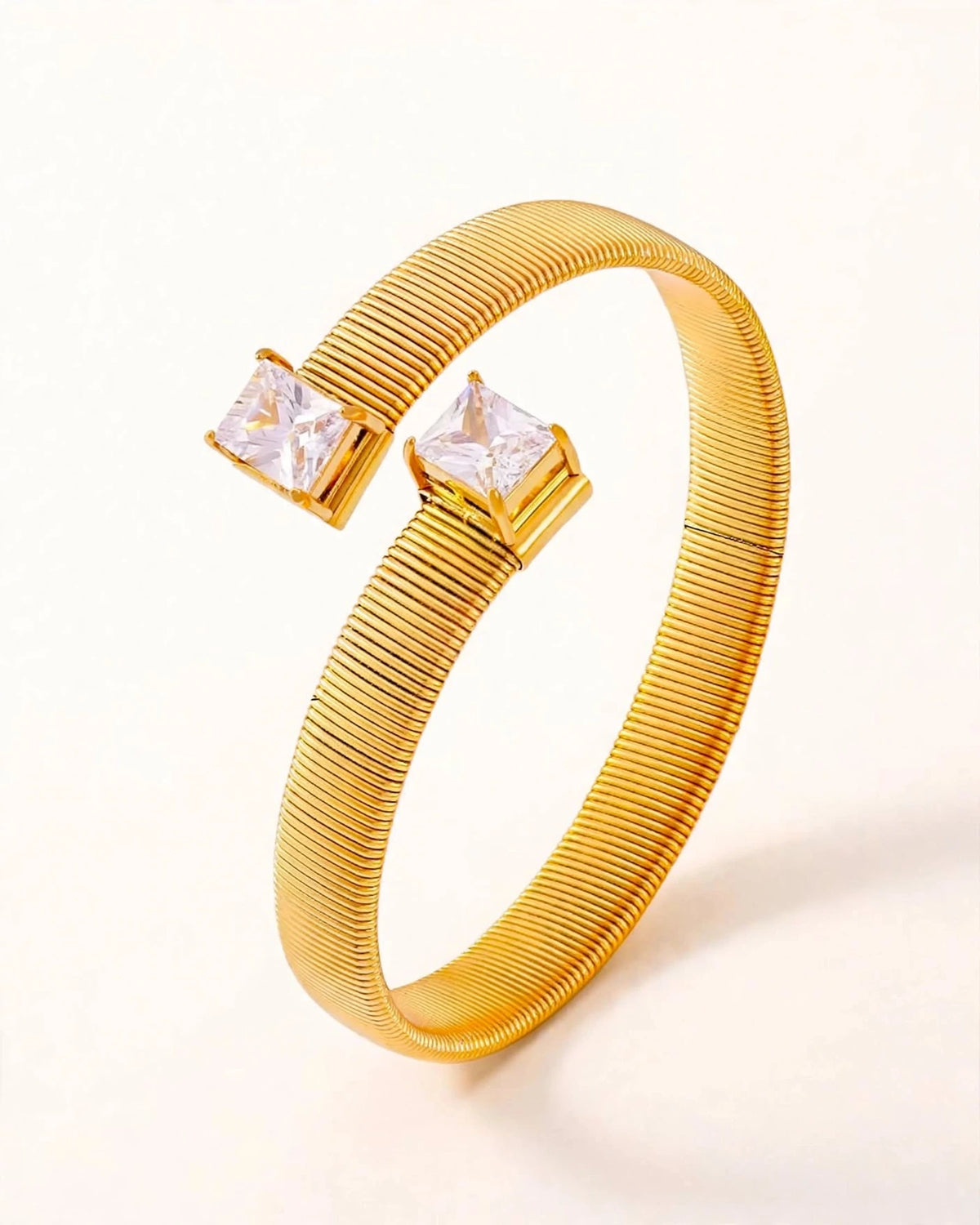 Macro close-up of gold ribbed cuff bracelet with dual rectangular CZ stones showing texture