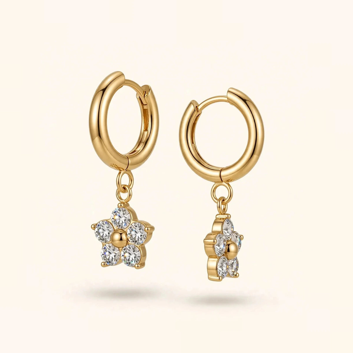 Gold huggie hoops with white zircon flower pendants, front and side view pair.