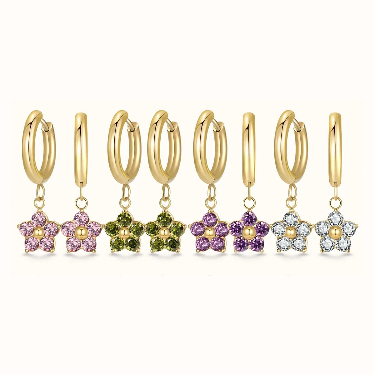 Four gold flower huggie earrings in pink, green, purple, white in one row on white