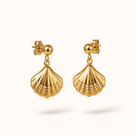 Gold seashell scallop drop earrings with ball stud floating on warm off-white.
