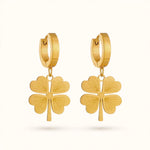 Gold four-leaf clover drop earrings with hinged hoop on off-white background