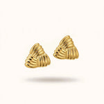 old triangular ribbed earrings pair floating on warm off-white background.