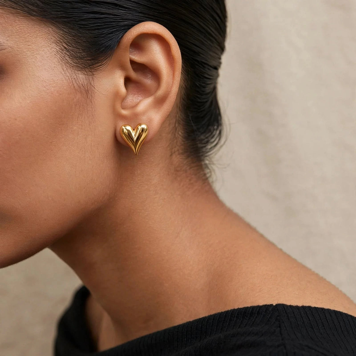 Indian woman in black off-shoulder top wearing gold puffed heart stud earring