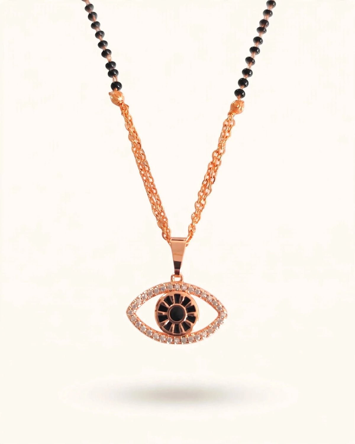 Rose gold evil eye mangalsutra with black bead mixed chain and diamond evil eye pendant on warm off-white