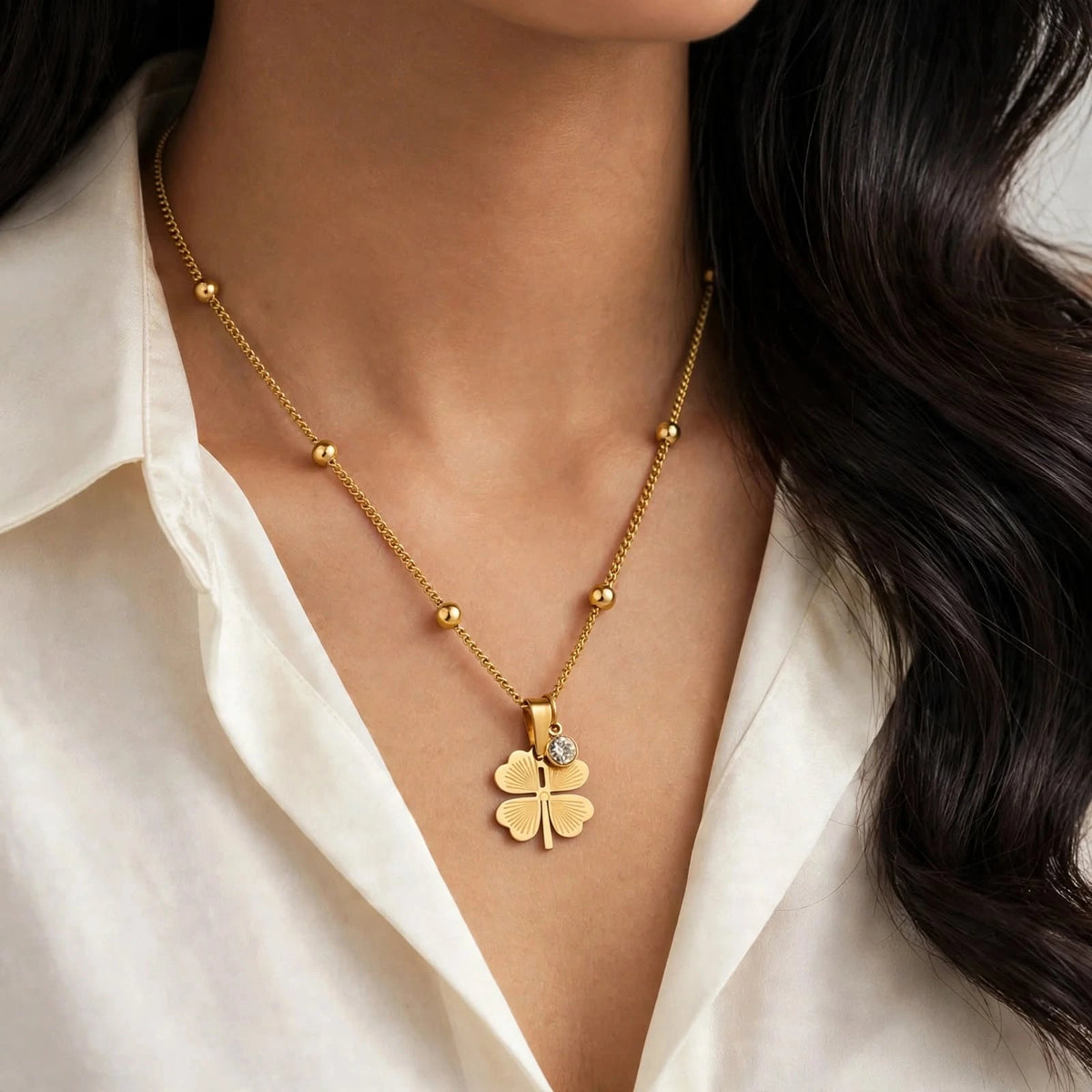 Indian woman in ivory silk shirt wearing gold clover necklace with long neck view