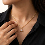 Model in black cotton shirt touching collarbone wearing triangular crystal pendant